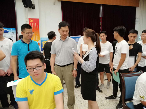 万世明院长(第二排中)在招聘会现场和企业代表交流.png