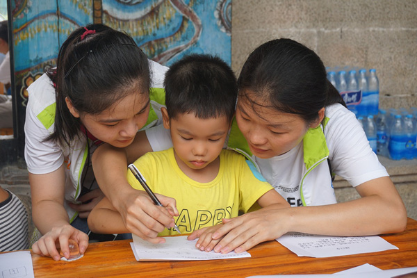 志愿者对小朋友做学业辅导 志愿者对小朋友做学业辅导